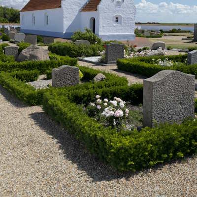 Kirkegård med grus og flisebelægning